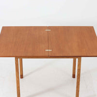 Borge Mogensen(ボーエ・モーエンセン)がSoborgのために手掛けた「Folding table」は、チーク材の天板とオーク材の脚部を組み合わせた温かみある佇まいが魅力のダイニングテーブルで、中央の蝶番を開閉して幅80~120cmへと柔軟に調整できる構造が特徴です。内部にはモーエンセン家具らしい実用性を備えた収納スペースが設けられ、ゲームテーブルとして親しまれてきた背景を感じさせます。経年により深まった木肌の風合いがビンテージならではの味わいをまとい、ダイニングやワークスペースのサブテーブルとしても多用途に活躍する一台です。また、裏面には「SKM」の刻印が確認でき、スウェーデン軍(Svenska KrigsMakten)の備品として使用されていたことを示しています。