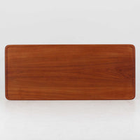 Hans J. Wegner(ハンス・J・ウェグナー)によるAndreas Tuck社製のセンターテーブル「AT11」です。幅130cmの広々とした天板はチーク無垢材を使用し、縁には繊細な面取り加工が施され、柔らかな印象を与えます。脚部には堅牢なオーク無垢材が用いられ、軽やかなテーパードデザインが北欧家具らしいバランスの良さを感じさせます。さらに脚のネジ部分まで木製で仕上げられており、細部に至るまで職人技が光る逸品です。脚は取り外し可能な構造で、輸送や設置も容易です。シンプルでありながら素材の美しさが際立ち、経年変化による深みを増した木肌がビンテージならではの存在感を放ちます。リビングの中心に置いて使うことで、空間に上質な雰囲気を添える一台です。