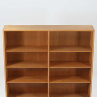 Borge Mogensenがデザインし、Karl Andersson & Sonerが製作した幅135cmのブックシェルフです。上質なオーク材を用いた無駄のない直線的な構成が特徴で、中央の仕切りにより整然とした収納を実現しています。固定棚による堅牢な構造は、日常使いの書籍や資料をしっかりと支え、空間に落ち着いた存在感をもたらします。素材の質感を活かした端正な佇まいは、リビングや書斎、オフィスにも自然に馴染み、北欧ビンテージならではの実直な美しさと経年変化の魅力を感じられる一品です。