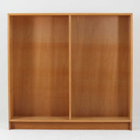 Borge Mogensenがデザインし、Karl Andersson & Sonerが製作した幅135cmのブックシェルフです。上質なオーク材を用いた無駄のない直線的な構成が特徴で、中央の仕切りにより整然とした収納を実現しています。固定棚による堅牢な構造は、日常使いの書籍や資料をしっかりと支え、空間に落ち着いた存在感をもたらします。素材の質感を活かした端正な佇まいは、リビングや書斎、オフィスにも自然に馴染み、北欧ビンテージならではの実直な美しさと経年変化の魅力を感じられる一品です。