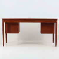 Borge MogensenがSoborg Mobler社のためにデザインしたModel 130の両袖デスクです。良質なチーク材を全面に使用した仕様は珍しく、温かみと重厚感を兼ね備えています。右側には3杯の引き出し、左側には1杯の深型引き出しを備えた構成もスタンダードな3段+2段タイプとは異なる希少なディテールです。幅146cmと程よいサイズ感で、書斎やオフィスに取り入れやすく、実用性と存在感を兼ね備えています。直線的で力強いフォルムはモーエンセンらしい機能美を体現し、経年により深みを増したチーク材の風合いが空間に格調を添えるビンテージデスクです。