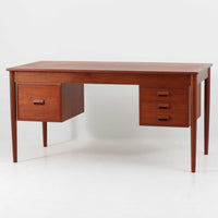 Borge MogensenがSoborg Mobler社のためにデザインしたModel 130の両袖デスクです。良質なチーク材を全面に使用した仕様は珍しく、温かみと重厚感を兼ね備えています。右側には3杯の引き出し、左側には1杯の深型引き出しを備えた構成もスタンダードな3段+2段タイプとは異なる希少なディテールです。幅146cmと程よいサイズ感で、書斎やオフィスに取り入れやすく、実用性と存在感を兼ね備えています。直線的で力強いフォルムはモーエンセンらしい機能美を体現し、経年により深みを増したチーク材の風合いが空間に格調を添えるビンテージデスクです。