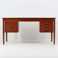 Borge MogensenがSoborg Mobler社のためにデザインしたModel 130の両袖デスクです。良質なチーク材を全面に使用した仕様は珍しく、温かみと重厚感を兼ね備えています。右側には3杯の引き出し、左側には1杯の深型引き出しを備えた構成もスタンダードな3段+2段タイプとは異なる希少なディテールです。幅146cmと程よいサイズ感で、書斎やオフィスに取り入れやすく、実用性と存在感を兼ね備えています。直線的で力強いフォルムはモーエンセンらしい機能美を体現し、経年により深みを増したチーク材の風合いが空間に格調を添えるビンテージデスクです。