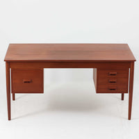 Borge MogensenがSoborg Mobler社のためにデザインしたModel 130の両袖デスクです。良質なチーク材を全面に使用した仕様は珍しく、温かみと重厚感を兼ね備えています。右側には3杯の引き出し、左側には1杯の深型引き出しを備えた構成もスタンダードな3段+2段タイプとは異なる希少なディテールです。幅146cmと程よいサイズ感で、書斎やオフィスに取り入れやすく、実用性と存在感を兼ね備えています。直線的で力強いフォルムはモーエンセンらしい機能美を体現し、経年により深みを増したチーク材の風合いが空間に格調を添えるビンテージデスクです。