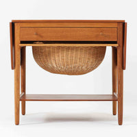 ハンス・J・ウェグナーが手がけ、Andreas Tuck社より製作されたAT33ソーイングテーブルは、天板を広げられる独創的な構造と実用性を兼ね備えた北欧ビンテージを代表する一台です。中央には引き出しと仕切り付き収納、下部にはラタンバスケットを備え、道具をすっきりと収められる設計が魅力。AT33は複数の素材構成で展開されたモデルですが、こちらは天板にチーク突板材、脚部にオーク無垢材を用いた仕様で、素材のコントラストと軽やかな佇まいが特徴です。異素材を巧みに組み合わせた構造と端正なプロポーションは、使うほどに職人技と経年変化の美しさを実感できます。