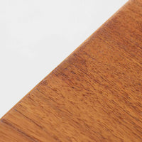 ハンス・J・ウェグナーが手がけ、Andreas Tuck社より製作されたAT33ソーイングテーブルは、天板を広げられる独創的な構造と実用性を兼ね備えた北欧ビンテージを代表する一台です。中央には引き出しと仕切り付き収納、下部にはラタンバスケットを備え、道具をすっきりと収められる設計が魅力。AT33は複数の素材構成で展開されたモデルですが、こちらは天板にチーク突板材、脚部にオーク無垢材を用いた仕様で、素材のコントラストと軽やかな佇まいが特徴です。異素材を巧みに組み合わせた構造と端正なプロポーションは、使うほどに職人技と経年変化の美しさを実感できます。