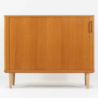 デンマーク製のボードです。温かみのあるオーク材を使用し、滑らかに開閉する蛇腹扉が特徴的な一台。内部は可動棚付きで収納力があり、食器や書類、日用品などをすっきりと収められます。丸みを帯びた脚部が軽やかな印象を与え、幅116cmの程よいサイズ感はリビングやダイニング、書斎にも取り入れやすい設計です。経年により深みを増した木目と丁寧なつくりから、北欧ビンテージならではの質実剛健な魅力が感じられる逸品です。