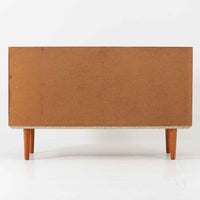 デンマーク製のこちらのローボードは、温かみあるチーク材を用いた端正な佇まいが魅力で、枠組みに厚みをもたせたスライド扉や細身のテーパー脚など、北欧ビンテージらしい上質な意匠が随所に感じられる一台です。内部は左右で棚構成が異なり、日用品から書類、メディア類まで整理しやすく、テレビボードやサイドキャビネットとしても活躍します。経年により深みを増した木肌の美しさと、シンプルながら丁寧に仕上げられた職人技が空間に落ち着きと温もりを添えるビンテージ家具です。