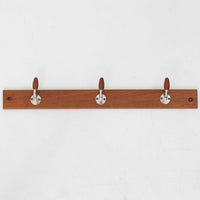 チーク材の温かみあるベースにメタル製の3連フックを組み合わせたデンマーク製のウォールハンガーです。丸みのある木製キャップ付きのフックはコートやバッグを掛けても傷つきにくく、機能性とデザイン性を両立した北欧ビンテージらしいディテールが魅力です。玄関や寝室、ワークスペースなど壁面を活用した収納に便利で、単体での使用はもちろん複数並べて使用しても美しく空間に溶け込みます。ミニマルなデザインでインテリアを選ばず永くお使いいただけるアイテムです。