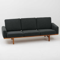 Hans J. Wegnerがデザインし、Getamaより製作された「GE236」トリプルソファです。オーク材のフレームに、背面の横桟が美しく並ぶ構造が特徴で、後ろ姿まで洗練された佇まいを見せるウェグナーらしいデザイン。クッション内部にはスプリングが内包されており、程よい弾力と快適な座り心地を実現しています。落ち着いた色合いの張地が木部の温かな表情を引き立てる、北欧ビンテージを代表する名作ソファです。