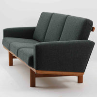 Hans J. Wegnerがデザインし、Getamaより製作された「GE236」トリプルソファです。オーク材のフレームに、背面の横桟が美しく並ぶ構造が特徴で、後ろ姿まで洗練された佇まいを見せるウェグナーらしいデザイン。クッション内部にはスプリングが内包されており、程よい弾力と快適な座り心地を実現しています。落ち着いた色合いの張地が木部の温かな表情を引き立てる、北欧ビンテージを代表する名作ソファです。