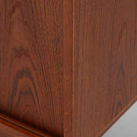 デンマーク製ローボードです。チーク材ならではの赤みを帯びた美しい木目が前面にあらわれ、引き戸には掘り込み式の丸い取っ手を配したミニマルな意匠が北欧らしい静かな存在感を放ちます。幅80cmの小ぶりなサイズ感で、リビングのテレビ台としてはもちろん、書斎やベッドルームでの収納家具としても取り入れやすく、内部には棚板を備え実用性も十分です。経年によって深みを増した木肌の表情と丁寧なつくりが、ビンテージならではの温もりを空間に添えてくれる一台です。