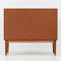 デンマーク製ローボードです。チーク材ならではの赤みを帯びた美しい木目が前面にあらわれ、引き戸には掘り込み式の丸い取っ手を配したミニマルな意匠が北欧らしい静かな存在感を放ちます。幅80cmの小ぶりなサイズ感で、リビングのテレビ台としてはもちろん、書斎やベッドルームでの収納家具としても取り入れやすく、内部には棚板を備え実用性も十分です。経年によって深みを増した木肌の表情と丁寧なつくりが、ビンテージならではの温もりを空間に添えてくれる一台です。