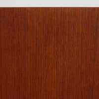 北欧ビンテージらしい端正な佇まいが魅力の小ぶりなボードです。深みのある色合いが美しいチーク材が用いられ、木目の表情と経年変化による艶感が空間に落ち着きを与えます。引き戸仕様の扉は前後にスペースを取らず、限られた空間でも扱いやすい構造です。内部には棚板を備え、食器や書類、小物類まですっきりと収納可能。幅80cmのコンパクトなサイズ感は、リビングのサブ収納や玄関、書斎など多用途に活躍し、北欧家具ならではの実用性と素材の良さを感じさせる一台です。