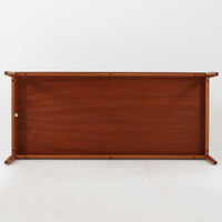 Grete Jalk(グレーテ・ヤルク)によるデザイン、France & Son社製のセンターテーブル Model 622/54です。繊細なテーパードレッグに天板と幕板の隙間を持たせた軽やかな構造が美しく、真鍮パーツがアクセントとして上質な存在感を添えています。幅150cmのゆったりとしたサイズはリビングでの使用に最適で、ソファ前のテーブルとしてはもちろん展示台としてもバランスよく馴染みます。北欧モダンを象徴する端正なラインとチーク材の豊かな木目が魅力で、ロゴプレートの仕様より1960年代半ば〜1969年頃に製造された個体と推測され、ミッドセンチュリー期を代表する名作ビンテージ家具です。