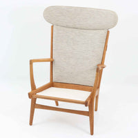 Hans J. Wegnerがデザインし、AP Stolenが製作したAP15ハイバックシングルソファです。オーク材の滑らかな木肌を活かしたフレームに、包み込むような背とヘッドレストを備えた優美なフォルムが印象的。彫刻的なアーム形状や前後に傾斜した脚部など、随所にウェグナーらしい造形美が感じられます。ホワイト系の色味が空間を明るく上品な印象に整えます。ゆったりと身体を預けられる快適な座り心地と、経年で深みを増した木部の風合いが格調ある雰囲気をもたらす北欧ビンテージの名品です。