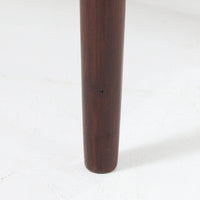 デンマーク製のサイドチェストです。チーク材ならではの温かみある木目と落ち着いた色合いが美しく、側板を立ち上げた天板形状がさりげないデザインアクセントになっています。引き出しには手掛けとして一体成形された取っ手があしらわれ、滑らかな開閉とすっきりとした正面意匠を両立しています。幅52cmの扱いやすいサイズ感で、ベッドサイドやソファ脇、玄関先などにも取り入れやすく、下段の棚板は本や小物の収納にも便利です。経年変化によって深みを増したチークの表情が、ビンテージならではの落ち着いた存在感を空間にもたらします。