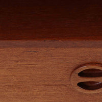 デンマーク製のサイドチェストで、温かみのあるチーク材を用いた北欧ビンテージらしい佇まいが魅力です。上段のオープンスペースは読みかけの本や小物の収納に便利で、下段の引き出しにはアイコン的な丸型取手があしらわれ、シンプルな中にも愛嬌のあるアクセントを添えています。細く伸びたテーパードレッグが軽やかな印象を与え、ベッドサイドやソファ横のサイドテーブルとしても活躍。経年変化による深い色艶が空間に上質な雰囲気をもたらすビンテージ家具です。