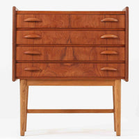 チーク材とオーク材を組み合わせた4段チェストです。前板には美しい木目を持つチーク材、脚部には明るく堅牢なオーク材が用いられ、素材のコントラストが北欧らしい洗練された印象を与えます。緩やかな曲線を描く取手や、すっきりとしたプロポーションが全体を端正にまとめ、コンパクトな幅59cmながら十分な収納力を備えています。リビングや寝室、書斎などさまざまな空間に取り入れやすく、ビンテージならではの風合いと実用性を兼ね備えた一台です。