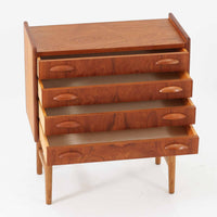 チーク材とオーク材を組み合わせた4段チェストです。前板には美しい木目を持つチーク材、脚部には明るく堅牢なオーク材が用いられ、素材のコントラストが北欧らしい洗練された印象を与えます。緩やかな曲線を描く取手や、すっきりとしたプロポーションが全体を端正にまとめ、コンパクトな幅59cmながら十分な収納力を備えています。リビングや寝室、書斎などさまざまな空間に取り入れやすく、ビンテージならではの風合いと実用性を兼ね備えた一台です。