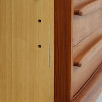 Johannes Andersenがデザインし、C.F.C. Silkeborgが製作した幅200cmのサイドボードです。チーク材の豊かな木目を活かした滑らかな曲面フレームと、横へ流れるように開閉する蛇腹扉が印象的で、端正さの中に軽やかなリズムを生み出します。中央の4段引き出しと両側の収納スペースにより高い収納力を備え、内部の棚板は可動式で実用性も良好。すらりと伸びる脚部が全体に洗練された印象を与え、空間に北欧ビンテージならではの気品と存在感をもたらします。