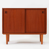 チーク材とビーチ材を組み合わせた北欧ビンテージのローボードで、直線的で端正なフォルムの中に素材の表情が美しく表れた一台です。引き戸仕様の前面は空間をすっきりと見せ、コンパクトなサイズ感ながら内部は左右に分かれた収納構造で、オーディオ機器や書類、小物類まで整理しやすい設計です。脚付き構造による軽やかな佇まいと、経年によって深みを増した木肌の風合いが、当時の丁寧なつくりとビンテージならではの存在感を感じさせ、リビングや書斎、寝室の収納家具として幅広く活躍します。