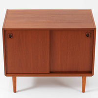 チーク材とビーチ材を組み合わせた北欧ビンテージのローボードで、直線的で端正なフォルムの中に素材の表情が美しく表れた一台です。引き戸仕様の前面は空間をすっきりと見せ、コンパクトなサイズ感ながら内部は左右に分かれた収納構造で、オーディオ機器や書類、小物類まで整理しやすい設計です。脚付き構造による軽やかな佇まいと、経年によって深みを増した木肌の風合いが、当時の丁寧なつくりとビンテージならではの存在感を感じさせ、リビングや書斎、寝室の収納家具として幅広く活躍します。