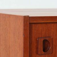 チーク材とビーチ材を組み合わせた北欧ビンテージのローボードで、直線的で端正なフォルムの中に素材の表情が美しく表れた一台です。引き戸仕様の前面は空間をすっきりと見せ、コンパクトなサイズ感ながら内部は左右に分かれた収納構造で、オーディオ機器や書類、小物類まで整理しやすい設計です。脚付き構造による軽やかな佇まいと、経年によって深みを増した木肌の風合いが、当時の丁寧なつくりとビンテージならではの存在感を感じさせ、リビングや書斎、寝室の収納家具として幅広く活躍します。