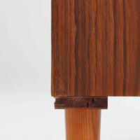 スウェーデン製ボードです。チーク材の温かみある木目を活かしたシンプルな箱型フォルムに、小ぶりな取っ手が愛らしいアクセントとなっています。引き戸仕様のため開閉スペースを取らず、内部には棚板を備え実用性も良好。幅88cmのコンパクトなサイズ感で、リビングや玄関、寝室など様々な空間に取り入れやすい一台です。経年により深みを増した木肌が北欧ビンテージならではの落ち着いた存在感を演出します。