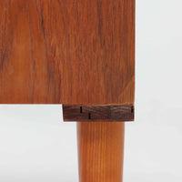 スウェーデン製ボードです。チーク材の温かみある木目を活かしたシンプルな箱型フォルムに、小ぶりな取っ手が愛らしいアクセントとなっています。引き戸仕様のため開閉スペースを取らず、内部には棚板を備え実用性も良好。幅88cmのコンパクトなサイズ感で、リビングや玄関、寝室など様々な空間に取り入れやすい一台です。経年により深みを増した木肌が北欧ビンテージならではの落ち着いた存在感を演出します。