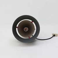 Jo HammerborgがFog & Morupのために手掛けた「Corona」は、直径22cmとコンパクトながら全高45cmと縦にしっかりとした存在感を持つアルミ×スチール製ペンダントライトで、上下に伸びる円錐形フォルムと中央のブラックバンドが彫刻的な印象を与える北欧ビンテージ品です。光源を囲む二重構造によって眩しさを抑えつつ下方向へ明かりを集中的に落とす設計となっており、ダイニングやカウンター上での1灯使用はもちろん、複数灯を並べても空間にリズムを生み出します。経年で深まった素材の風合いがハーマボーらしいモダンな佇まいを際立たせ、空間のアクセントとしても十分な存在感を発揮します。