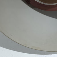 Jo HammerborgがFog & Morupのために手掛けた「Corona」は、直径22cmとコンパクトながら全高45cmと縦にしっかりとした存在感を持つアルミ×スチール製ペンダントライトで、上下に伸びる円錐形フォルムと中央のブラックバンドが彫刻的な印象を与える北欧ビンテージ品です。光源を囲む二重構造によって眩しさを抑えつつ下方向へ明かりを集中的に落とす設計となっており、ダイニングやカウンター上での1灯使用はもちろん、複数灯を並べても空間にリズムを生み出します。経年で深まった素材の風合いがハーマボーらしいモダンな佇まいを際立たせ、空間のアクセントとしても十分な存在感を発揮します。