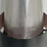 Jo HammerborgがFog & Morupのために手掛けた「Corona」は、直径22cmとコンパクトながら全高45cmと縦にしっかりとした存在感を持つアルミ×スチール製ペンダントライトで、上下に伸びる円錐形フォルムと中央のブラックバンドが彫刻的な印象を与える北欧ビンテージ品です。光源を囲む二重構造によって眩しさを抑えつつ下方向へ明かりを集中的に落とす設計となっており、ダイニングやカウンター上での1灯使用はもちろん、複数灯を並べても空間にリズムを生み出します。経年で深まった素材の風合いがハーマボーらしいモダンな佇まいを際立たせ、空間のアクセントとしても十分な存在感を発揮します。