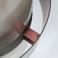 Jo HammerborgがFog & Morupのために手掛けた「Corona」は、直径22cmとコンパクトながら全高45cmと縦にしっかりとした存在感を持つアルミ×スチール製ペンダントライトで、上下に伸びる円錐形フォルムと中央のブラックバンドが彫刻的な印象を与える北欧ビンテージ品です。光源を囲む二重構造によって眩しさを抑えつつ下方向へ明かりを集中的に落とす設計となっており、ダイニングやカウンター上での1灯使用はもちろん、複数灯を並べても空間にリズムを生み出します。経年で深まった素材の風合いがハーマボーらしいモダンな佇まいを際立たせ、空間のアクセントとしても十分な存在感を発揮します。