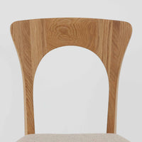 Niels Koefoedが1957年にデザインし、現在はCaso Furnitureより復刻製作されているモデル「Peter」のダイニングチェアです。オーク材の美しい木目を活かしたフレームと、背もたれに大きく設けられたアーチ状の開口部が印象的で、軽やかさと構造的な強度を両立したデザインが特徴です。身体をやさしく受け止める背のラインと、適度なクッション性を備えた座面により、日常使いにおいても快適な座り心地を実現しています。素材の質感を活かしたシンプルな佇まいは、ダイニング空間に自然と馴染み、北欧ミッドセンチュリー期のデザインらしい温かみと洗練を感じさせる一脚です。