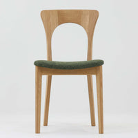 Niels Koefoedが1957年にデザインし、現在はCaso Furnitureより復刻製作されているモデル「Peter」のダイニングチェアです。オーク材の美しい木目を活かしたフレームと、背もたれに大きく設けられたアーチ状の開口部が印象的で、軽やかさと構造的な強度を両立したデザインが特徴です。身体をやさしく受け止める背のラインと、適度なクッション性を備えた座面により、日常使いにおいても快適な座り心地を実現しています。素材の質感を活かしたシンプルな佇まいは、ダイニング空間に自然と馴染み、北欧ミッドセンチュリー期のデザインらしい温かみと洗練を感じさせる一脚です。