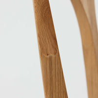 Niels Koefoedが1957年にデザインし、現在はCaso Furnitureより復刻製作されているモデル「Peter」のダイニングチェアです。オーク材の美しい木目を活かしたフレームと、背もたれに大きく設けられたアーチ状の開口部が印象的で、軽やかさと構造的な強度を両立したデザインが特徴です。身体をやさしく受け止める背のラインと、適度なクッション性を備えた座面により、日常使いにおいても快適な座り心地を実現しています。素材の質感を活かしたシンプルな佇まいは、ダイニング空間に自然と馴染み、北欧ミッドセンチュリー期のデザインらしい温かみと洗練を感じさせる一脚です。