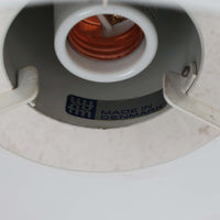 Jo HammerborgがFog & Morupのためにデザインした「Equator」は、直径40cmの存在感あるスチール製ペンダントライトで、赤・黄色・青など多彩なカラーバリエーションが展開されていたモデルとして知られますが、本品は空間に優しく溶け込む上品なホワイトカラーが採用されています。スチール特有の程よい重量感と重厚な佇まいがあり、実際に吊るすとホワイトの柔らかな印象の中にしっかりとした質感が感じられるのも魅力です。同心円状に重なるシェードが光を柔らかく分散させ、眩しさを抑えつつ立体的な陰影を生み出す構造が特徴で、ダイニングやリビングの主照明として落ち着きのあるモダンなアクセントを添えます。ミニマルな造形の中に職人技が凝縮されており、経年で深まった塗装の質感がビンテージならではの魅力を一層引き立てています。