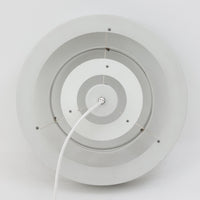 Jo HammerborgがFog & Morupのためにデザインした「Equator」は、直径40cmの存在感あるスチール製ペンダントライトで、赤・黄色・青など多彩なカラーバリエーションが展開されていたモデルとして知られますが、本品は空間に優しく溶け込む上品なホワイトカラーが採用されています。スチール特有の程よい重量感と重厚な佇まいがあり、実際に吊るすとホワイトの柔らかな印象の中にしっかりとした質感が感じられるのも魅力です。同心円状に重なるシェードが光を柔らかく分散させ、眩しさを抑えつつ立体的な陰影を生み出す構造が特徴で、ダイニングやリビングの主照明として落ち着きのあるモダンなアクセントを添えます。ミニマルな造形の中に職人技が凝縮されており、経年で深まった塗装の質感がビンテージならではの魅力を一層引き立てています。