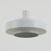 Jo HammerborgがFog & Morupのためにデザインした「Equator」は、直径40cmの存在感あるスチール製ペンダントライトで、赤・黄色・青など多彩なカラーバリエーションが展開されていたモデルとして知られますが、本品は空間に優しく溶け込む上品なホワイトカラーが採用されています。スチール特有の程よい重量感と重厚な佇まいがあり、実際に吊るすとホワイトの柔らかな印象の中にしっかりとした質感が感じられるのも魅力です。同心円状に重なるシェードが光を柔らかく分散させ、眩しさを抑えつつ立体的な陰影を生み出す構造が特徴で、ダイニングやリビングの主照明として落ち着きのあるモダンなアクセントを添えます。ミニマルな造形の中に職人技が凝縮されており、経年で深まった塗装の質感がビンテージならではの魅力を一層引き立てています。