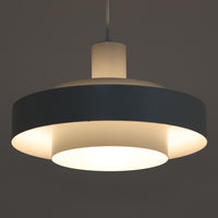 Jo HammerborgがFog & Morupのためにデザインした「Equator」は、直径40cmの存在感あるスチール製ペンダントライトで、赤・黄色・青など多彩なカラーバリエーションが展開されていたモデルとして知られますが、本品は空間に優しく溶け込む上品なホワイトカラーが採用されています。スチール特有の程よい重量感と重厚な佇まいがあり、実際に吊るすとホワイトの柔らかな印象の中にしっかりとした質感が感じられるのも魅力です。同心円状に重なるシェードが光を柔らかく分散させ、眩しさを抑えつつ立体的な陰影を生み出す構造が特徴で、ダイニングやリビングの主照明として落ち着きのあるモダンなアクセントを添えます。ミニマルな造形の中に職人技が凝縮されており、経年で深まった塗装の質感がビンテージならではの魅力を一層引き立てています。