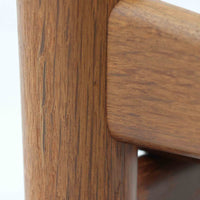 Hans J. Wegnerがデザインし、Getamaが製作したGE530オットマンです。ダークオーク材の力強い木目を活かした角の取れたフレームと、丸脚を組み合わせた端正な構造が特徴で、裏面には刻印も確認できます。程よい厚みのクッションは張り替え済みで、軽やかな生地が木部の深みのある色合いを引き立てます。同シリーズのラウンジチェアと合わせてはもちろん、単体でスツールや補助椅子としても活躍する、北欧ビンテージならではの質実剛健な一品です。