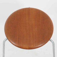 Arne Jacobsen(アルネ・ヤコブセン)がFritz Hansen(フリッツ・ハンセン)のために手掛けた有名なドットスツールは、チーク材の座面とスチールレッグを組み合わせた軽快な佇まいが魅力の北欧ビンテージ家具で、中でも希少なチークモデルとなるこちらは滑らかに成形された丸い座面が身体に心地よくフィットし、わずかに外側へ開いた3本脚が安定感を確保しつつ空間に軽やかな印象を添え、ミニマルな構造に宿る職人技と経年で深まった木肌と金属のコントラストが美しく、ダイニングのサブチェアや玄関、デスク横のサイドスツールとしても取り入れやすい一脚です。