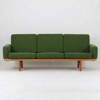 Hans J. Wegnerがデザインし、Getamaより製作されたGE236トリプルソファです。オーク材のフレームと直線を基調とした端正なフォルムが美しく、背面に配された横桟の意匠は後ろ姿まで印象的に演出します。ゆったりとした3人掛けの座面とクッションは快適な座り心地を実現し、リビングの主役として存在感を放ちます。ウェグナーらしい機能美と職人技が息づく設計に加え、経年により深みを増した木肌の風合いが北欧ビンテージならではの魅力を引き立てる希少な一台です。