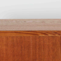 ボーエ・モーエンセンが手がけ、FDB Moblerより製作された北欧ビンテージのブックシェルフです。オーク材の木目を活かした端正で実直な佇まいは、生活に寄り添う家具を追求したデザイン哲学を色濃く感じさせます。左右に分かれた棚構成は収納力に優れ、書籍や器、オブジェまで整然と収められる構造です。特徴的な脚部は後年に付け替えられたものではなく、FDB社で製造されたオリジナル仕様で、取り外すと刻印が確認できます。全体に軽やかさと安定感を与える脚部と、長年の使用によって深みを増した素材感が相まい、空間に静かな存在感とビンテージならではの魅力を添える一台です。