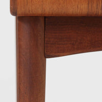 Johannes Andersen(ヨハネス・アンダーセン)がCFC Silkeborgのために手掛けた2段チェストは、チーク材を贅沢に用いた柔らかな曲面フォルムと長く伸びた彫刻的なハンドルが印象的で、天板から側面へと美しくつながる木目が上質な素材感を際立たせる北欧ビンテージ家具です。職人技の光る滑らかな面取りや端正な造りが深い味わいを生み出し、コンパクトながら実用的な2杯の引き出しを備え、ベッドサイドやリビングのサイドテーブルとしても活躍し、温かみのある木肌の経年変化が魅力を一層引き立てています。