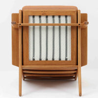 Hans J. Wegnerがデザインし、Getama社によって製作されたGE290は、構造の美しさと快適な座り心地を兼ね備えた北欧ビンテージを代表するシングルソファです。厚みのあるクッションと緩やかに傾斜した背もたれが身体を包み込み、自然と深いリラックス姿勢へと導きます。クッション内部にはビンテージ品ならではのスプリングが内包されており、しっかりとした弾力と安定感のある座り心地を生み出しています。オーク材のフレームは力強さと温かみを併せ持ち、アームから脚部にかけての造形にはウェグナーらしい彫刻的な魅力が感じられます。張地の落ち着いた色合いと、経年により深みを増した木部の表情が調和し、リビングや書斎で長く寄り添う一脚です。