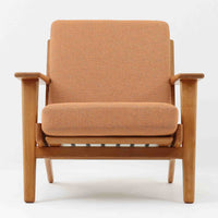Hans J. Wegnerがデザインし、Getama社によって製作されたGE290は、構造の美しさと快適な座り心地を兼ね備えた北欧ビンテージを代表するシングルソファです。厚みのあるクッションと緩やかに傾斜した背もたれが身体を包み込み、自然と深いリラックス姿勢へと導きます。クッション内部にはビンテージ品ならではのスプリングが内包されており、しっかりとした弾力と安定感のある座り心地を生み出しています。オーク材のフレームは力強さと温かみを併せ持ち、アームから脚部にかけての造形にはウェグナーらしい彫刻的な魅力が感じられます。張地の落ち着いた色合いと、経年により深みを増した木部の表情が調和し、リビングや書斎で長く寄り添う一脚です。