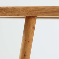 Hans J. Wegnerがデザインし、Getama社によって製作されたGE290は、構造の美しさと快適な座り心地を兼ね備えた北欧ビンテージを代表するシングルソファです。厚みのあるクッションと緩やかに傾斜した背もたれが身体を包み込み、自然と深いリラックス姿勢へと導きます。クッション内部にはビンテージ品ならではのスプリングが内包されており、しっかりとした弾力と安定感のある座り心地を生み出しています。オーク材のフレームは力強さと温かみを併せ持ち、アームから脚部にかけての造形にはウェグナーらしい彫刻的な魅力が感じられます。張地の落ち着いた色合いと、経年により深みを増した木部の表情が調和し、リビングや書斎で長く寄り添う一脚です。