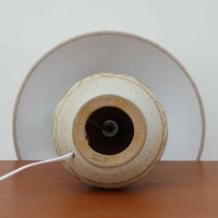 スーホルム・セラミック(Soholm Keramik)によるこちらのテーブルランプは、温かみのある陶磁器ベースに柔らかなブラウンとブルーで描かれた連続模様が印象的で、どこか手仕事の息づかいを感じさせる北欧ビンテージらしい魅力を備えています。丸みを帯びたベースからすっと伸びる首部のラインが美しく、リネンシェードを通した穏やかな灯りが空間にやさしい陰影を生み出します。高さ35cmと日常使いしやすいサイズで、ベッドサイドやリビングのサイドテーブルにも程よく収まり、落ち着いたインテリアに自然に馴染む一台です。